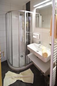 a white bathroom with a shower and a sink at Pension Seiwald in Kötschach Kärnten in Kötschach