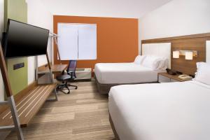 Holiday Inn Express & Suites San Antonio - Downtown Market Area, an IHG Hotel في سان انطونيو: غرفة فندقية بسريرين وتلفزيون بشاشة مسطحة