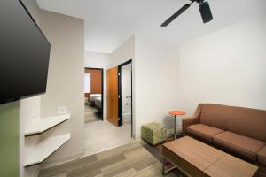 uma sala de estar com um sofá e uma televisão em Holiday Inn Express & Suites San Antonio - Downtown Market Area, an IHG Hotel em San Antonio