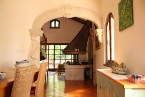 a kitchen with an archway and a table with chairs at Holiday Home Natural Art House in Višnjan