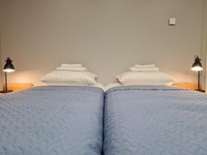 two beds with white sheets and towels on top of them at Narva Port Hostel in Narva