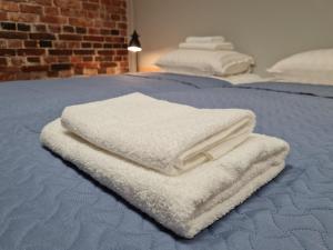 dwa białe ręczniki siedzące na łóżku w obiekcie Narva Port Hostel w mieście Narwa