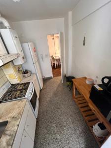 cocina con electrodomésticos blancos y mesa de madera en Hermoso departamento céntrico de dos ambientes. en Rosario