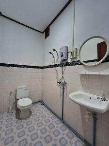 a bathroom with a sink and a toilet and a mirror at Saphaothong guesthouse in Vang Vieng