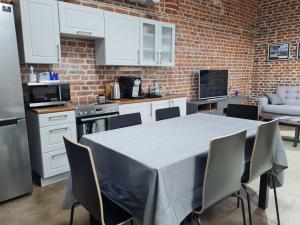a kitchen with a table and a brick wall at Narva Port Hostel in Narva