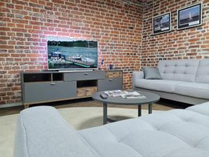 a living room with two couches and a flat screen tv at Narva Port Hostel in Narva