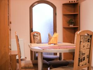 a dining room table with chairs and a mirror at Apartament Centrul Vechi in Curtea de Argeş