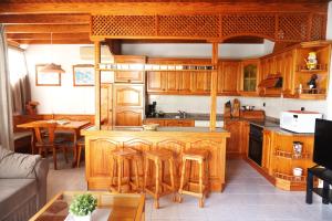 kuchnia z drewnianymi szafkami i stołem z krzesłami w obiekcie Apartamento Costa, cerca de la playa y comercios. w Costa Teguise