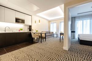 kuchnia i salon z kanapą i stołem w obiekcie VacationClub - Baltic Park Fort Apartament G.405 w Świnoujściu