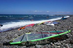 un groupe de planches de surf sur une plage rocheuse dans l'établissement Sweet Home Pozo Izquierdo A, à Pozo Izquierdo