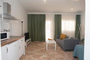 sala de estar con sofá y cortinas verdes en Siempreviva, en Agüimes