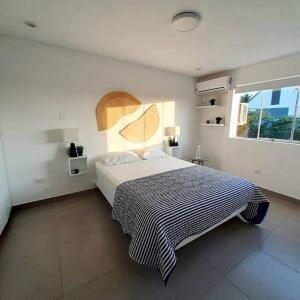a bedroom with a large bed and a window at Departamento Las Palmeras de Bocapán 201 in Zorritos
