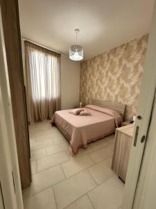 una camera con letto rosa e finestra di Casa Lulú a Napoli