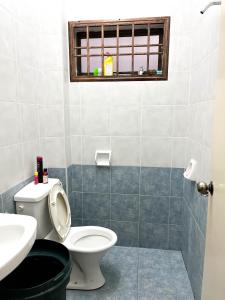 baño con aseo y lavabo y ventana en Muar Homestay [Located at Sabak Awor Seafood Court], en Muar
