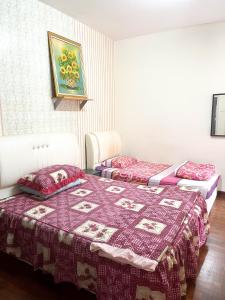 2 camas en una habitación con edredón en Muar Homestay [Located at Sabak Awor Seafood Court], en Muar