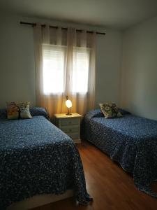 1 dormitorio con 2 camas y una lámpara en una mesa en Oasis de paz en el Campo de Gibraltar, en Los Barrios