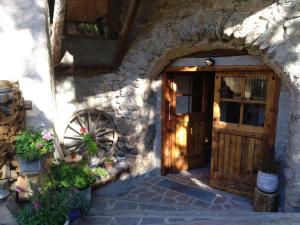 wejście do kamiennego budynku z drewnianymi drzwiami w obiekcie La Maïta w mieście Montgenèvre