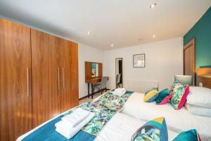 1 dormitorio con 2 camas y armario de madera en The Shore Apartment, en Queensferry