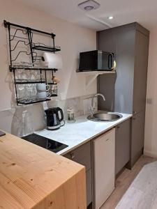 a kitchen with a sink and a counter top at Little Slioch Cottage- A Break From City Life in Avoch