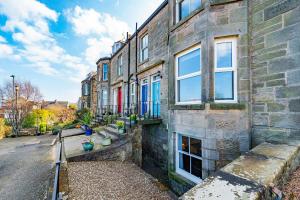 an old brick building with windows on a street at The Shore Apartment in Queensferry