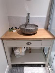 a bathroom counter with a sink on a wooden counter top at Little Slioch Cottage- A Break From City Life in Avoch