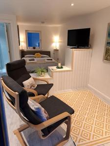 a living room with two beds and a television at Little Slioch Cottage- A Break From City Life in Avoch