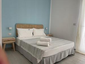プンタ・プロシュートにあるApartments Punta Grossaのベッドルーム1室(ベッド1台、タオル2枚付)
