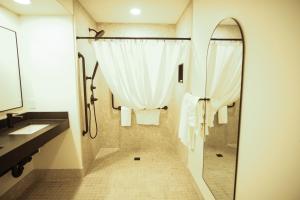 a bathroom with a shower and a sink and a mirror at Baymont by Wyndham Fort McMurray in Fort McMurray