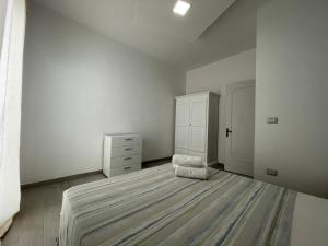 プンタ・プロシュートにあるApartments Punta Grossaの白いベッドルーム(ベッド1台、ドレッサー付)