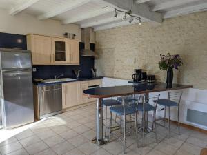 a kitchen with a table and some chairs in it at Gîte familial avec piscine, jardin clos, équipements bébé, animaux acceptés, Chadurie - FR-1-653-61 in Chadurie