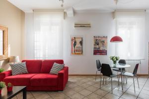 salon z czerwoną kanapą i stołem w obiekcie Portobello Apartments w Bolonii