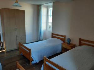 a bedroom with two beds and a window at Gîte typique Sud Charente, 2 chambres, terrasse, animaux acceptés, proche circuits randonnées - FR-1-653-78 in Salles-Lavalette
