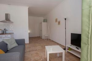 sala de estar con sofá, TV y mesa en Palmera, en Agüimes