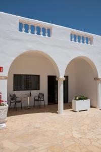 un grand bâtiment blanc avec des chaises et une table dans l'établissement Palmera, à Agüimes