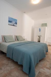 - une chambre blanche avec un lit et une couverture bleue dans l'établissement Palmera, à Agüimes 10 autres photos