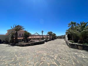 een pad met palmbomen en een gebouw op de achtergrond bij Palmera in Agüimes