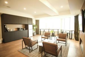 a living room with chairs and a table and a kitchen at Baymont by Wyndham Fort McMurray in Fort McMurray