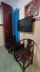 dwa krzesła i telewizor z płaskim ekranem na ścianie w obiekcie Hoàng Anh Hotel w Ho Chi Minh