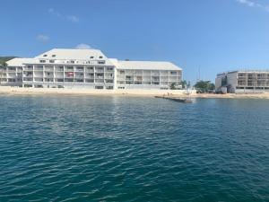 un gran edificio en la playa junto al agua en Grand Studio « Blue Sunset » mer, plage, piscine., en Marigot