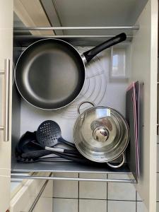 a frying pan and other utensils in a kitchen at Marienhaus Apartment - Zentral, Parken, Netflix, Kontaktloses Einchecken in Wuppertal