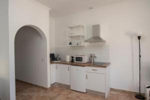 una cucina con mobili bianchi e un forno a microonde di Siempreviva ad Agüimes