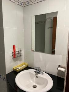 W łazience znajduje się umywalka i lustro. w obiekcie Hoàng Anh Hotel w Ho Chi Minh