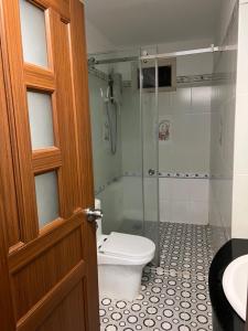 a bathroom with a toilet and a glass shower at Hoàng Anh Hotel in Ho Chi Minh City