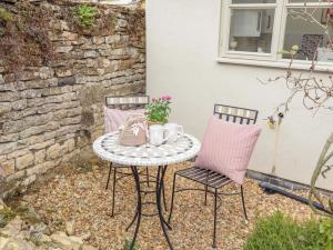 Pheasant Cottage في أوكهام: طاولة وكرسيين على الفناء
