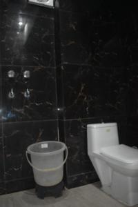 a bathroom with a toilet and a bucket at Hotel celebration in Alwar