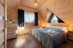 a bedroom with a bed in a wooden cabin at TATRAHOLIDAY- Domek na wierchu in Szaflary