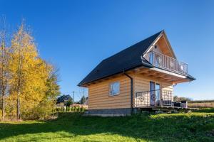 a log cabin with a balcony on a grass field at TATRAHOLIDAY- Domek na wierchu in Szaflary