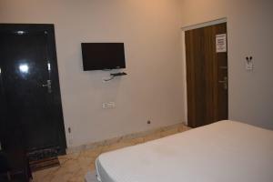 una camera da letto con un letto e una televisione a parete di Hotel celebration a Alwar