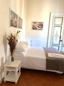 una camera con un letto bianco e un tavolo di Vicolo Doria Apartment a Roma