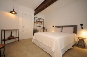 een witte slaapkamer met een groot wit bed in een kamer bij Villa Santa Fé in Búzios